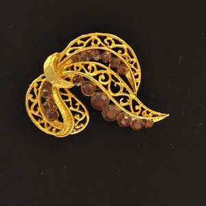 Gold trim with purple gem ribbon brooch